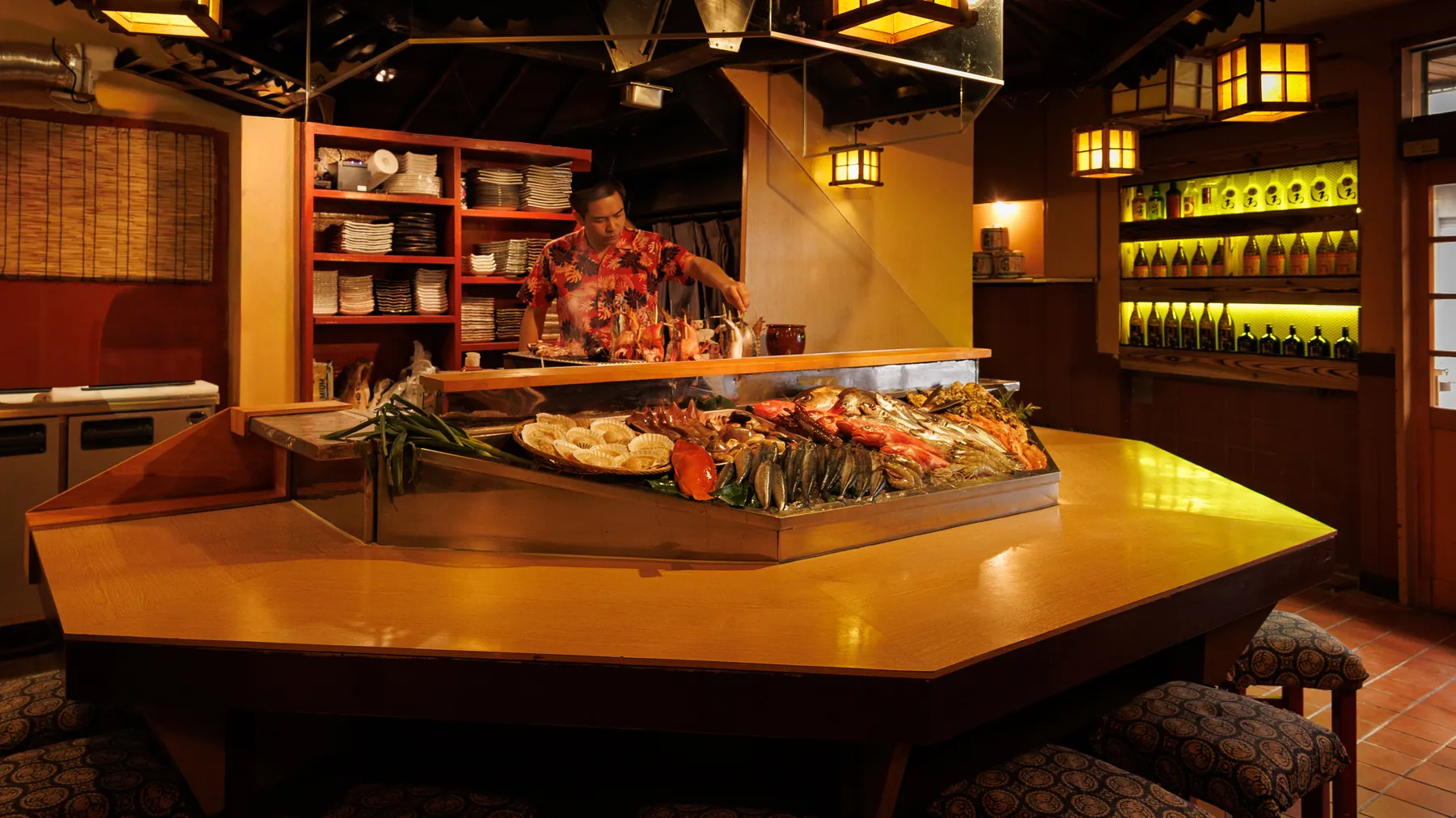 俺の炉端 またこよ 千葉店の炉端カウンター。旬の鮮魚が炭火のそばに並ぶ